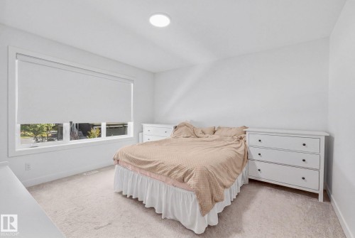 White walls, light-colored carpeting, a large window, and a flush-mount ceiling light - 4023 Hawthorn Link Link Sw, Edmonton, AB 