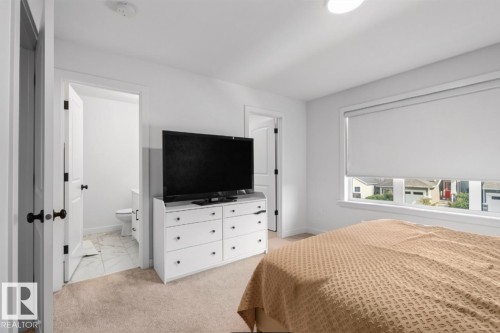 Recessed lighting, wide window with roller shade, and en-suite bathroom with tiled flooring - 4023 Hawthorn Link Link Sw, Edmonton, AB 