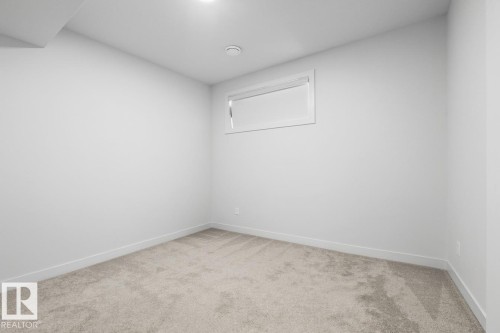 Recessed lighting, light-toned carpeting, and a single window with white trim - 4023 Hawthorn Link Link Sw, Edmonton, AB 