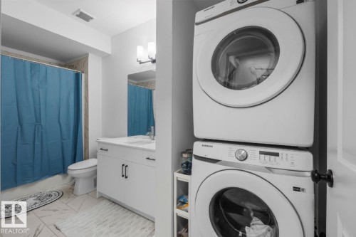 White vanity with a rectangular sink, wall-mounted faucet, and black hardware - 4023 Hawthorn Link Link Sw, Edmonton, AB 