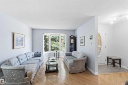 Living area featuring light wood-finish flooring and a multi-pane bay window - 