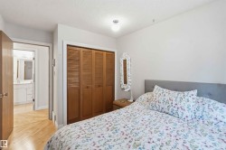 Bedroom featuring warm wood-finish flooring and a built-in closet with louvered bi-fold doors - 