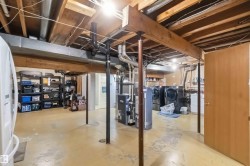 Lower level utility space featuring exposed wood joists and structural beams - 