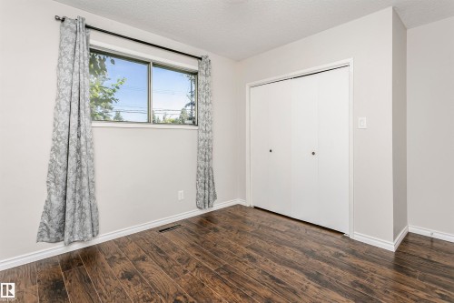 Wood-finish flooring, white walls, and a sliding door closet - 11440 44A Avenue Nw, Edmonton, AB 