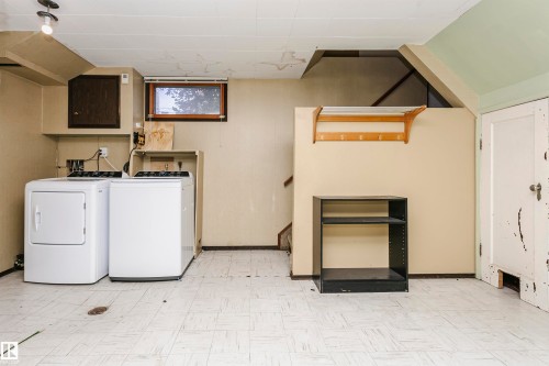 Laundry area featuring a window, overhead track lighting, and a white paneled door - 11440 44A Avenue Nw, Edmonton, AB 