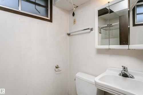 Wall-mounted sink with chrome faucet, white toilet, and medicine cabinet with mirrored doors - 11440 44A Avenue Nw, Edmonton, AB 