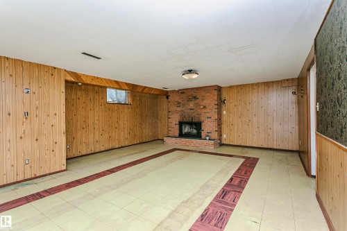 Wood-paneled walls and a brick fireplace with a raised hearth - 11440 44A Avenue Nw, Edmonton, AB 