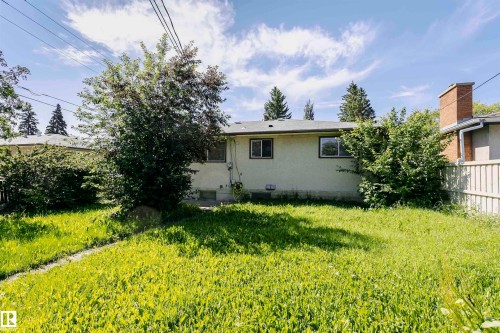 Expansive grassy area with mature trees and a brick chimney element - 11440 44A Avenue Nw, Edmonton, AB 