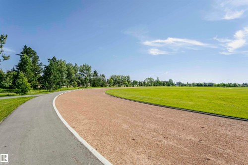Curved paved pathway with a white painted line, bordering a gravel track and extensive manicured green space - 11440 44A Avenue Nw, Edmonton, AB 
