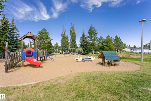 Community playground featuring a multi-level play structure with a slide, swings, and sandbox area - 11440 44A Avenue Nw, Edmonton, AB 