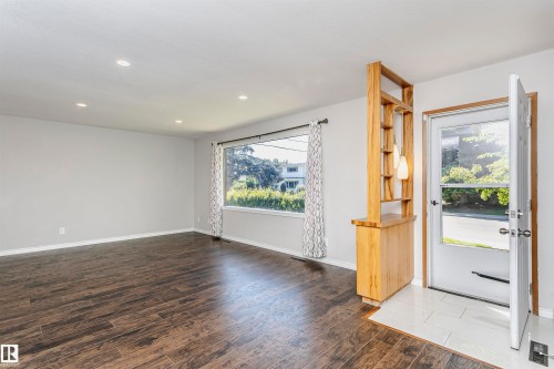 Wood-finish flooring, recessed ceiling lighting, front entry door with transom window, and a built-in wood divider with shelving - 11440 44A Avenue Nw, Edmonton, AB 