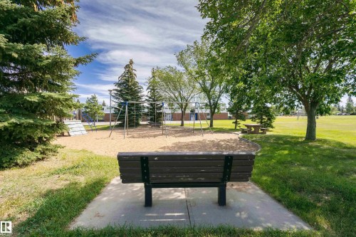 Outdoor playground with a sand base, swing sets, and a picnic table - 11440 44A Avenue Nw, Edmonton, AB 
