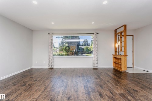 Wood-finish flooring throughout, recessed ceiling lighting, and a large picture window - 11440 44A Avenue Nw, Edmonton, AB 