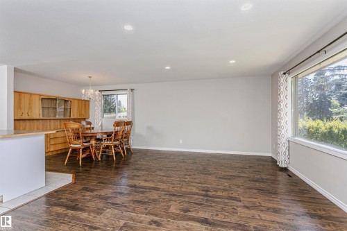 Expansive living area with wood-finish flooring, recessed lighting, and large windows - 11440 44A Avenue Nw, Edmonton, AB 