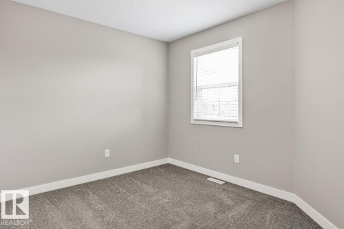 Carpeted flooring, white trim, window with blinds, and light-toned walls - 22 Hope Common, Spruce Grove, AB 