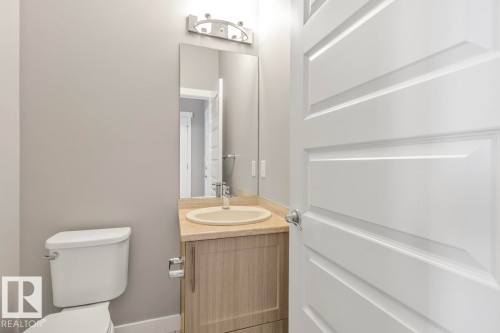 Vanity with integrated sink, light wood-finish cabinetry, and stone-finish countertop - 22 Hope Common, Spruce Grove, AB 