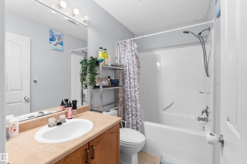 Single vanity with an integrated sink and wood-finish cabinetry - 13028 34 Street Nw, Edmonton, AB 