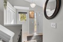 Vaulted ceiling with a flush-mount pendant light, paneled entry door with sidelights, and a window with roller blind - 13028 34 Street Nw, Edmonton, AB 