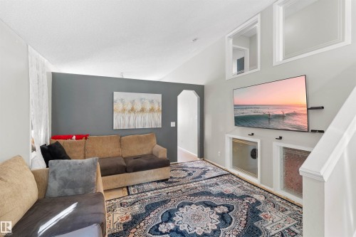 Vaulted ceiling, arched doorway, recessed wall niches, and wood-finish flooring - 13028 34 Street Nw, Edmonton, AB 