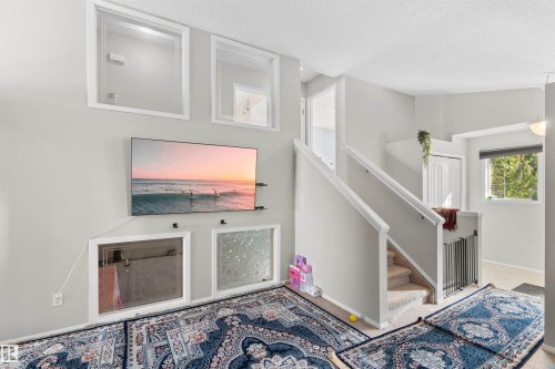 Carpeted staircase with white railing - 13028 34 Street Nw, Edmonton, AB 