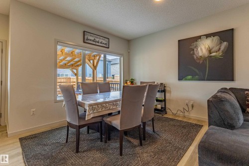 Dining area featuring wood-finish flooring and a large window - 41 Sequoia Bend, Fort Saskatchewan, AB 