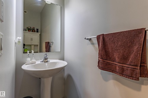 Pedestal sink with a chrome faucet, illuminated by an overhead light - 41 Sequoia Bend, Fort Saskatchewan, AB 