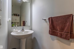 Pedestal sink with a chrome faucet, illuminated by an overhead light - 