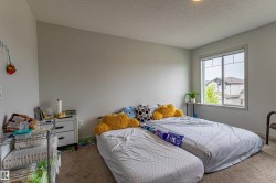 Carpeted bedroom with neutral wall tones and a window with white trim - 