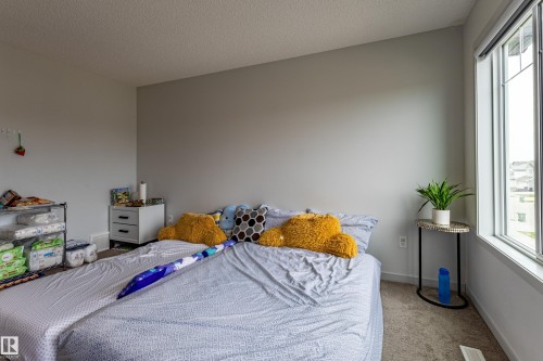 Carpeted room with a large window and neutral wall tones - 41 Sequoia Bend, Fort Saskatchewan, AB 