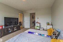 Carpeted room with light gray walls, a textured ceiling, and a white paneled door - 