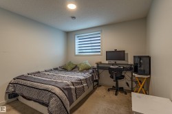 Bedroom featuring light neutral wall paint, a single window with blinds, and recessed ceiling lighting - 