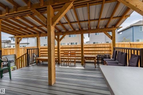 Expansive covered deck featuring wood framing, a metal roof, composite decking, and a wood privacy fence - 41 Sequoia Bend, Fort Saskatchewan, AB 