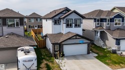 Contemporary two-story home featuring a combination of light and dark siding with black trim accents - 
