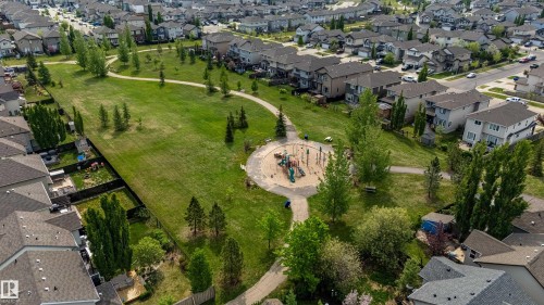 Expansive green space featuring a circular playground area, paved walking paths, and numerous mature trees - 41 Sequoia Bend, Fort Saskatchewan, AB 