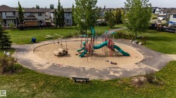 Community playground featuring sand base, multiple slides, swing sets, and climbing structures - 