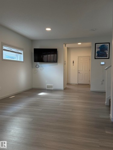 Living area featuring wood-finish flooring, recessed lighting, white trim, and a rectangular window with blinds - 41 Sequoia Bend, Fort Saskatchewan, AB 