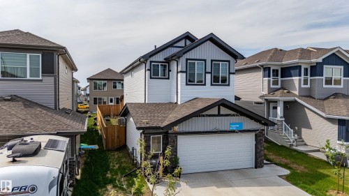 Contemporary two-story residence featuring a two-car garage, white siding, and dark trim accents - 41 Sequoia Bend, Fort Saskatchewan, AB 