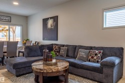 Open-concept living area featuring light-toned walls, recessed lighting, and wood-finish flooring - 