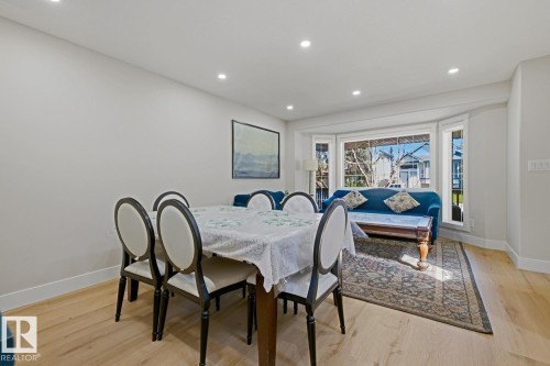 Recessed lighting illuminates the space, featuring a bay window, light wood-finish flooring, and white wall finishes - 3830 22 Street Nw, Edmonton, AB 