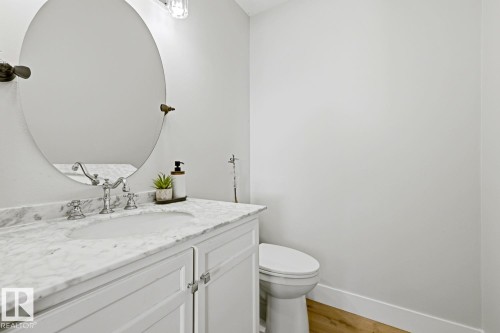 White vanity with panel-front cabinetry, a polished chrome faucet, and a round undermount sink - 3830 22 Street Nw, Edmonton, AB 