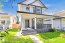 Two-story residence featuring light-colored siding, a covered front porch, and a dark front door - 3830 22 Street Nw, Edmonton, AB 