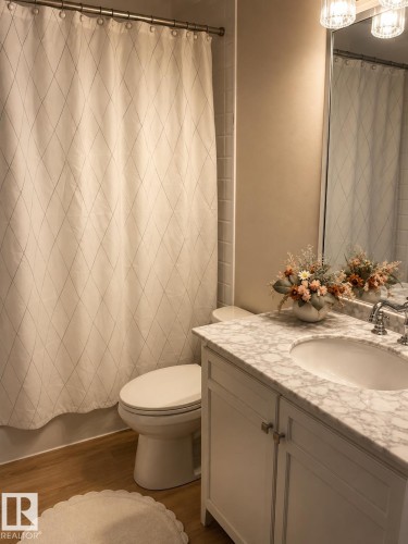 White vanity with polished chrome hardware, an integrated oval sink, and a light-toned countertop - 3830 22 Street Nw, Edmonton, AB 