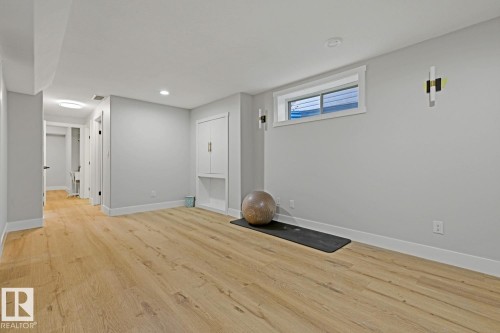 Wood-finish flooring, recessed lighting, built-in cabinetry, and modern wall sconces - 3830 22 Street Nw, Edmonton, AB 