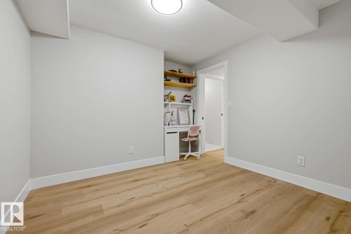 Light wood-finish flooring, built-in shelving, recessed lighting, and a neutral wall color - 3830 22 Street Nw, Edmonton, AB 