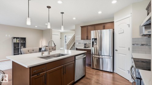 Kitchen featuring a center island with sink, stainless steel appliances, wood-finish flooring, recessed lighting, and pendant lighting fixtures - 4610 Westcliff Point(E) Sw, Edmonton, AB 