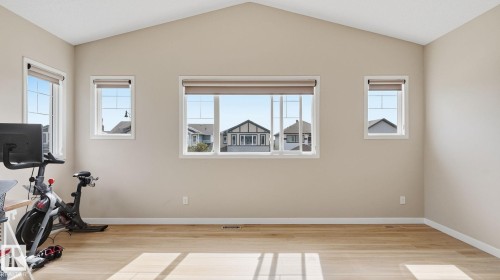Vaulted ceiling, multiple windows with roller shades, wood-finish flooring, and neutral wall tones - 4610 Westcliff Point(E) Sw, Edmonton, AB 