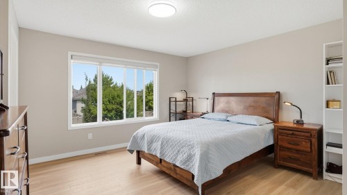Light wood-finish flooring, white trim, neutral wall paint, and a large window - 4610 Westcliff Point(E) Sw, Edmonton, AB 