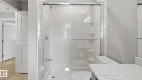 Glass-enclosed shower with a tiled surround and chrome fixtures - 4610 Westcliff Point(E) Sw, Edmonton, AB 