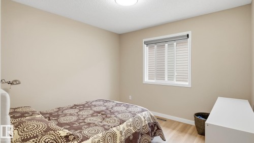 Neutral tone walls, wood-finish flooring, and a window with blinds and roller shade - 4610 Westcliff Point(E) Sw, Edmonton, AB 