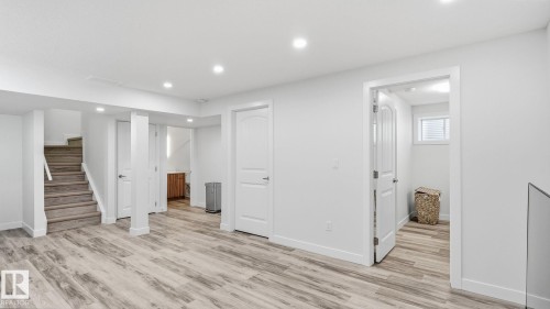Recessed lighting illuminating wood-finish flooring, white walls, and a stairway with wood treads - 4610 Westcliff Point(E) Sw, Edmonton, AB 